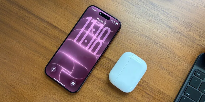 酒红色 iPhone 18 Pro 放在木桌上,旁边是耳机盒