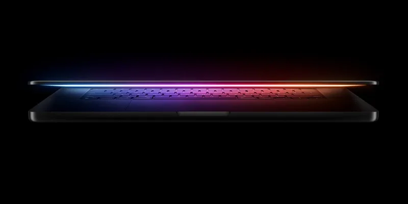 MacBook Pro 微开状态的侧面官方图,键盘透出彩虹色背光