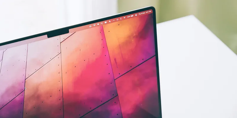 MacBook Pro 屏幕顶部的刘海特写,状态栏从两侧绕开