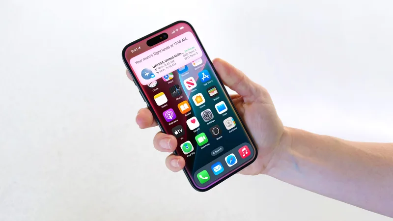 资料图:手持 iPhone。图片来源:MacRumors