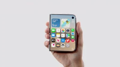 一只手握着的 iPhone Duo,亮起的屏幕显示天气小组件、应用图标网格与底部程序坞