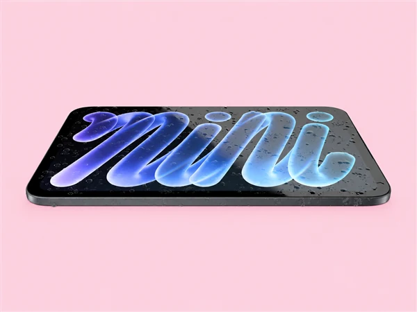 粉色背景上平放着一台深色 iPad mini,屏幕上发光的蓝色小写 mini 字样表面挂着水珠,机身下方可见接口与扬声器开孔