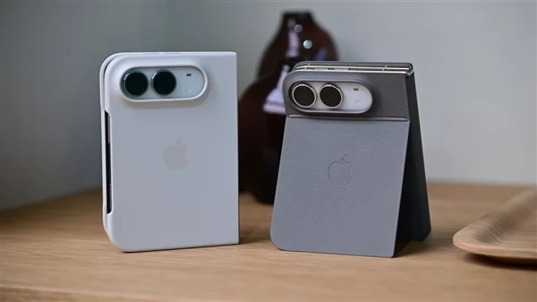 两台 iPhone Duo 折叠后背面朝上放在木桌上,左侧白色版本合盖平放,右侧深色版本半折立起,均可见横置的双摄模组
