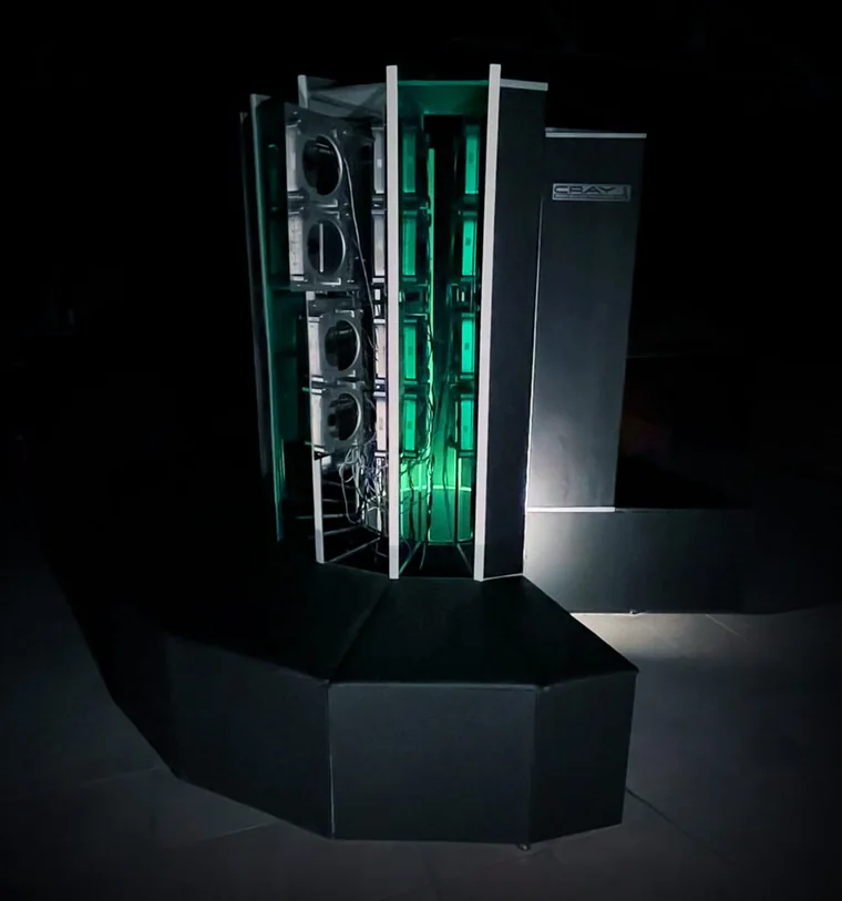 博物馆展出的 Cray-1 复制品夜景，绿色荧光映出机箱内部结构，CRAY 标志在侧板上