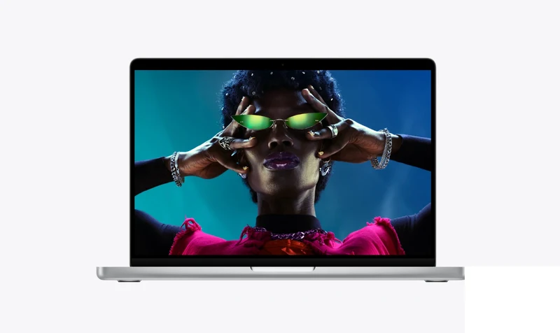 银色 MacBook Pro 开盖正面，屏幕显示彩妆人像摄影作品，窄边框与刘海摄像头可见