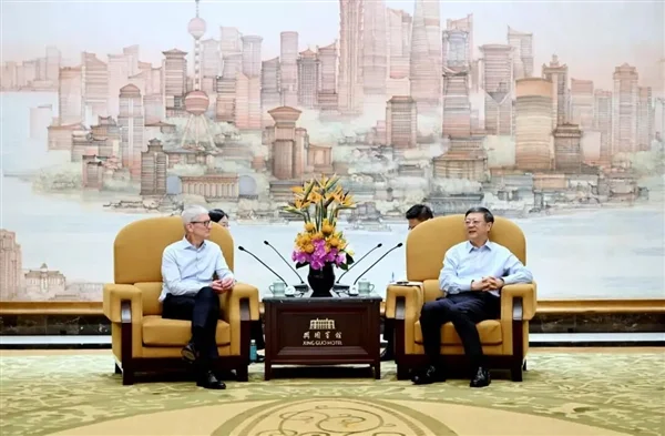 上海市委书记陈吉宁会见苹果执行董事长蒂姆·库克，两人在上海锦江宾馆落座交谈，背景为浦东风光壁画