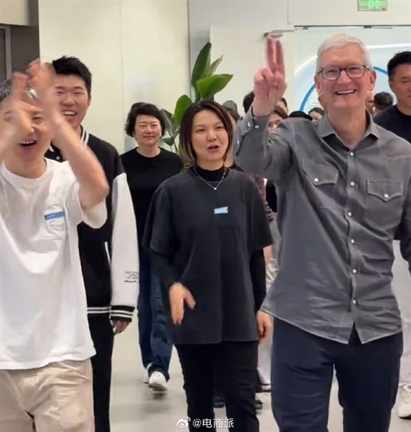 蒂姆·库克在米哈游总部招手示意，两侧员工鼓掌欢迎，库克身着灰色衬衫
