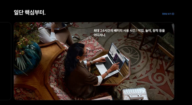韩国官网 MacBook Pro 页面截图:韩文标题「일단 핵심부터」与最长 24 小时电池续航文案,配图为用户在桌边使用笔记本电脑